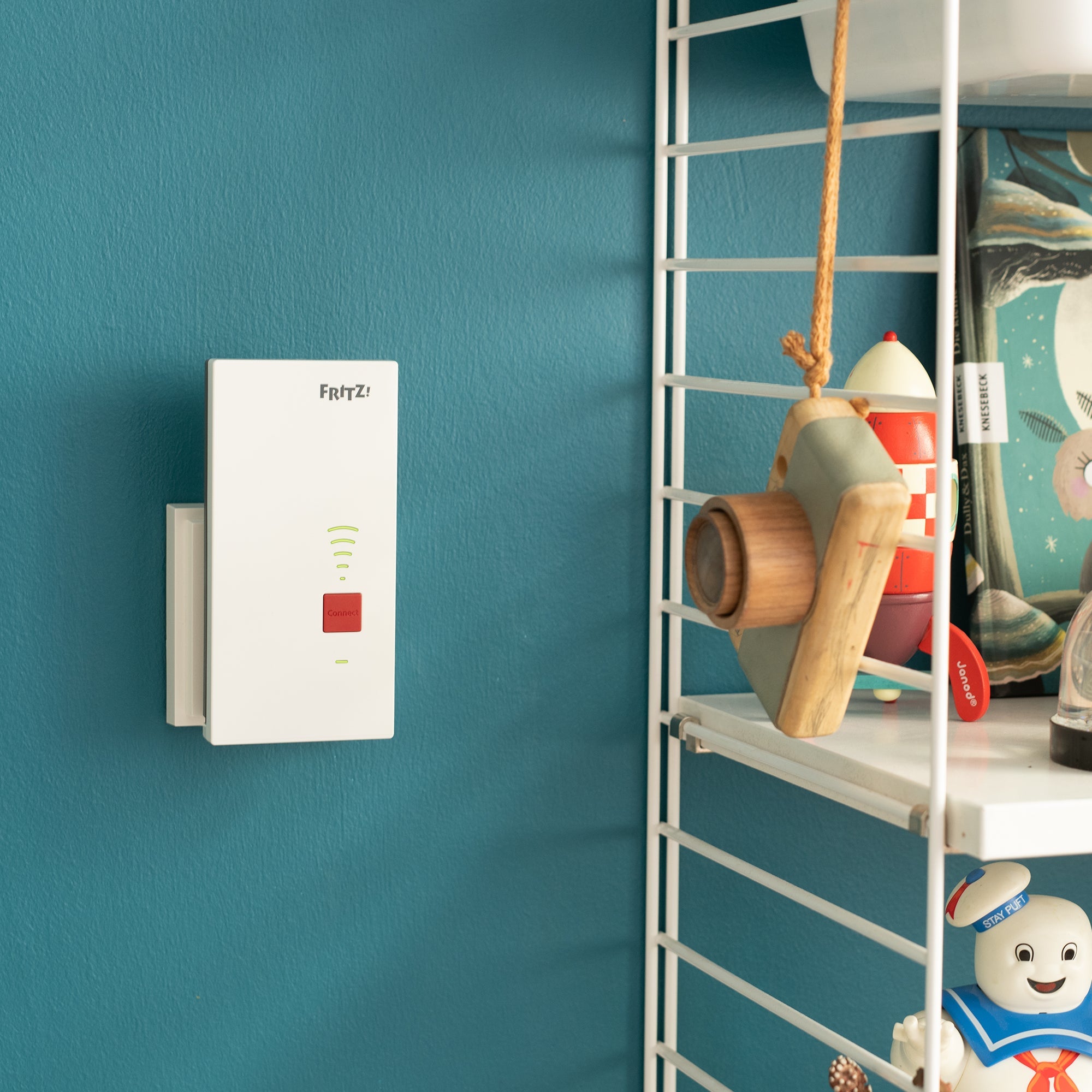 FRITZ!Repeater 2400 an einer Wand in modernem Zuhause, erweitert das WLAN-Signal.